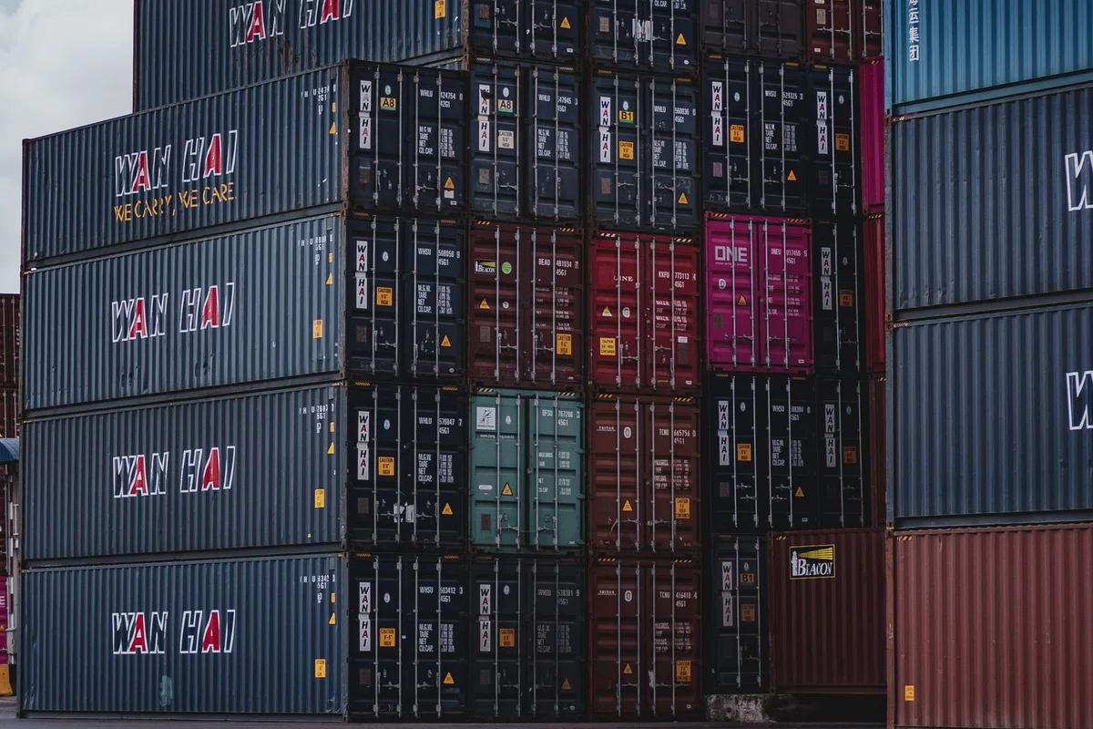 Stacked shipping containers representing inventory planning and global distribution for pet products