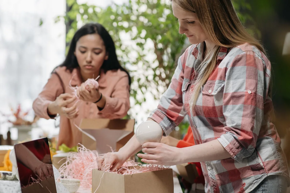 Small business team packing customer orders into branded boxes